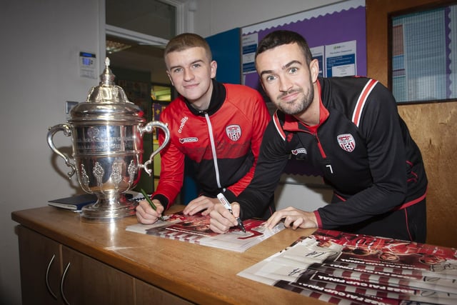 Derry City stars Caoimhin Porter and Michael Duffy signing autographs after arriving at Greenhaw PS on Monday with the FAI Cup. (Photos: Jim McCafferty Photography)