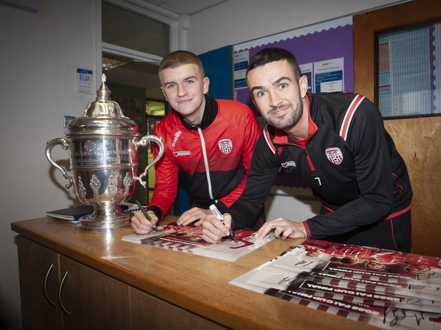 Derry City stars Caoimhin Porter and Michael Duffy signing autographs after arriving at Greenhaw PS on Monday with the FAI Cup. (Photos: Jim McCafferty Photography)