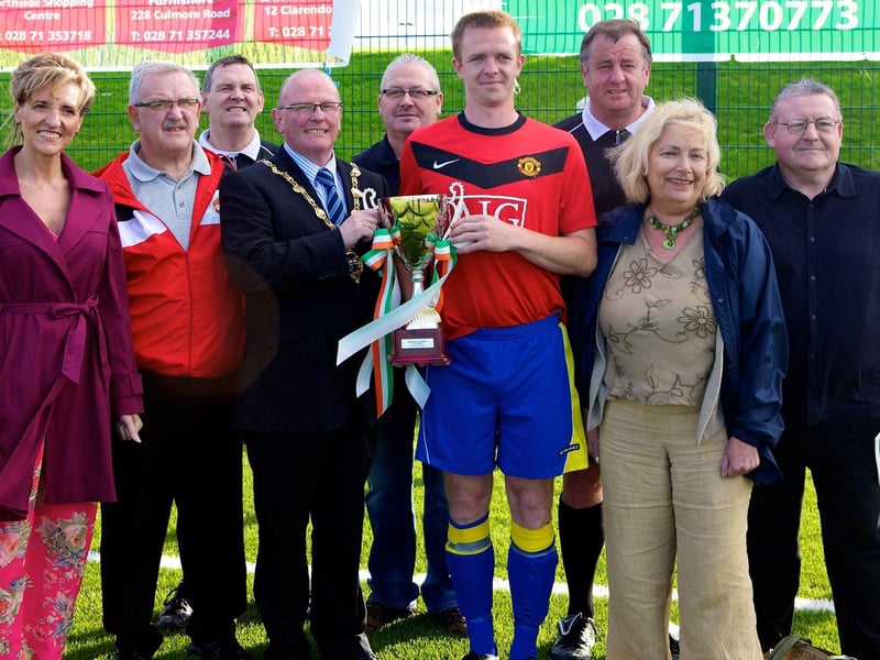 The Mayor of Derry, Councillor Kevin Campbell presents the Bronco/Heaney Cup to Ryan McCready, captain Marty's 9s winners, beating Foyle Harps, 4-2 in the final held at Leafair pitch on Saturday last. Included, from left, are Michael Gallagher, linesman, Martina Anderson, MLA, Martin Gallagher, Seamus Soal, linesman, Martin McGilloway, competition organiser, Noel Moore, referee, Pat Heaney, and Colr. Tony Hassan. 2808JM156