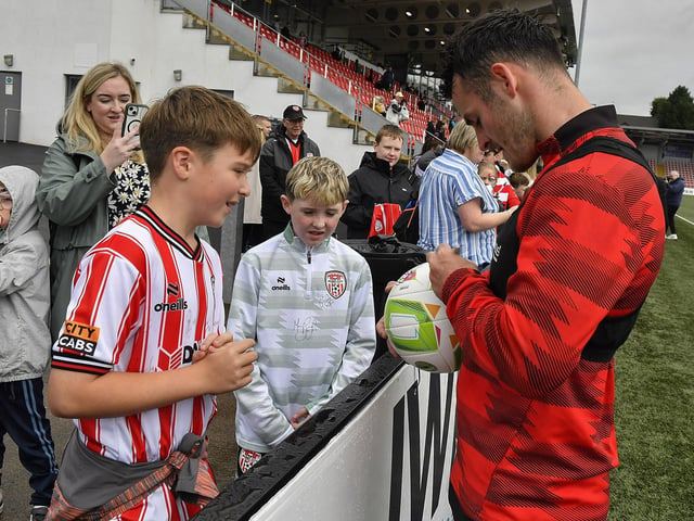 Danny Mullen signs a ball for a fan at the Derry City open training session on Monday morning in  Brandywell Stadium. The event was organised at part of the Gasyard Feile.  Photo: George Sweeney / Derry Journal