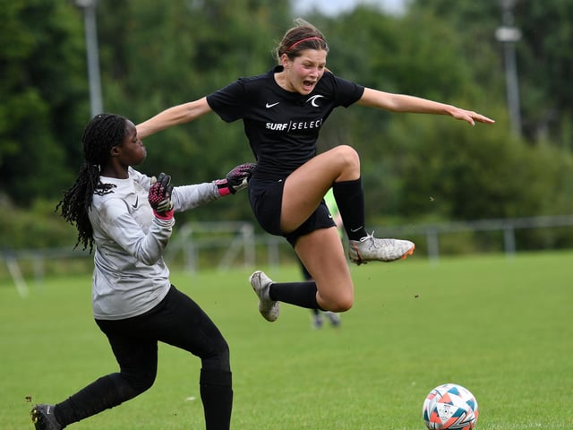 Surf Select (USA) Under-15's player Isabella Forrester hurdles this challenge from Mid Ulster Ladies keeper' Yara Lopes.