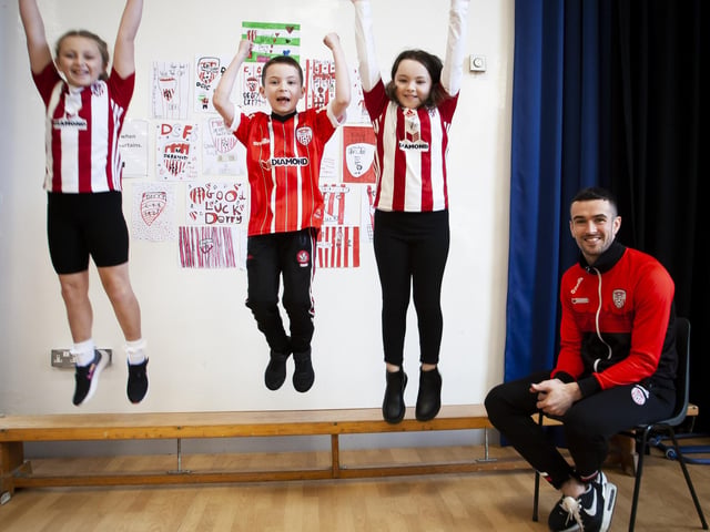 JUMPING FOR JOY: Three Steelstown Primary School pupils jumping for joy at the visit of Derry City's Michael Duffy on Tuesday.