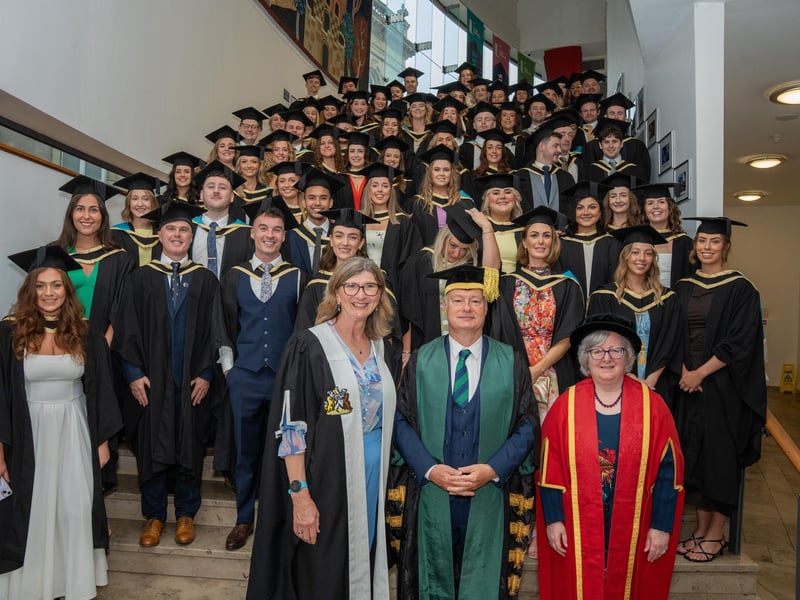 Professor Louise Dubras, Foundation Dean of the School of Medicine; Professor Paul Bartholomew, Vice-Chancellor of Ulster University; and Professor Carol Curran, Pro Vice-Chancellor and Executive Dean of the Faculty of Life and Health Sciences, alongside Ulster University's first graduating cohort of medical students.