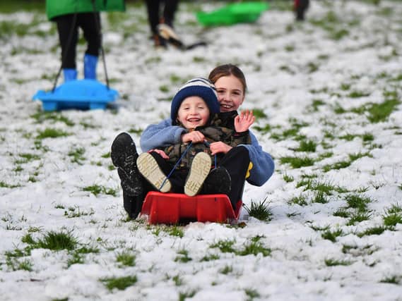 Children enjoy a day off school and a slide in the snow in Brooke Park on Thursday afternoon. Photo: George Sweeney