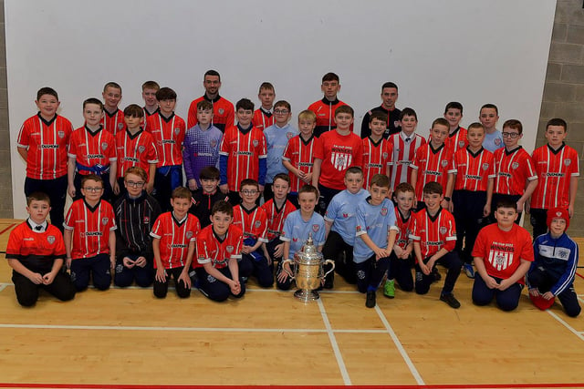 Derry City players Michael Duffy, Liam Mullan and Jordon McEneff  pictured with St Columb's College Year 8 soccer players during a visit to the school, with the FAI Cup, on Monday. Photo: George Sweeney. DER2247GS - 20
