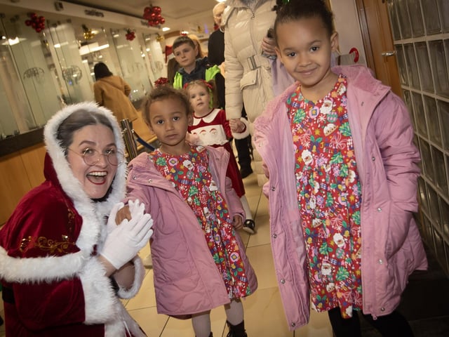 Mrs. Claus pictured with some of the children waiting to see Santa on Saturday. : .