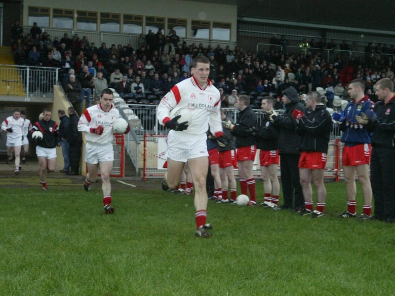 The Derry players form a guard of honour as reigning All Ireland champions Tyrone run out on to the Healy Park pitch in January 2004.