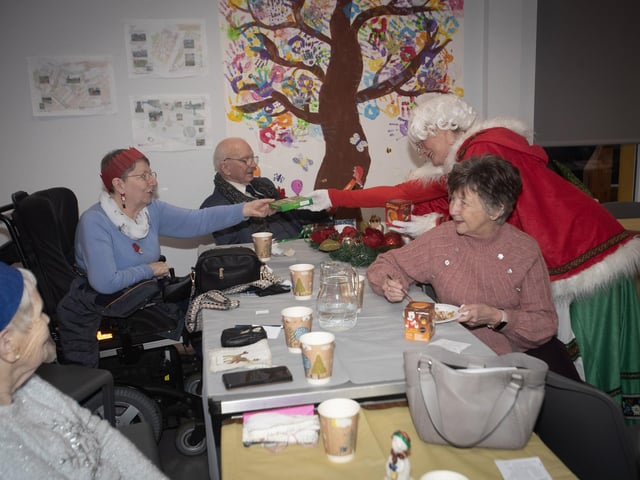 Mrs. Claus handing out gifts to those in attendance at last week's Christmas Party in the Catheral Youth Club.
