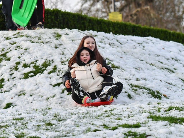 Children enjoy a day off school and a slide in the snow in Brooke Park on Thursday afternoon. Photo: George Sweeney