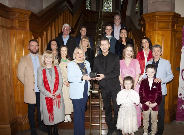 DAMIEN McGINTY HONOURED. . . . .The Mayor of Derry City and Strabane District Council, Sandra Duffy pictured making a special presentation to Damian McGinty in recognition of his recent success of getting to the finals of RTE’s Dancing With The Stars. Included are his wife, parents, siblings and family circle. (Photos: Jim McCafferty Photography)