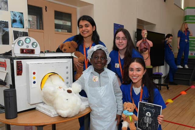 Ulster University medical students Diya Thomas, Luca Shannon and Jasmine Gallagher pictured with a pupil at the Teddy Bear Hospital event held in the Model Primary on Wednesday morning. Photo: George Sweeney