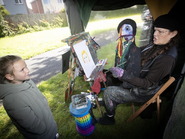Paddy Picasso painting a portrait of young Harper Robb during Saturday's Waterside Together Festival. : .