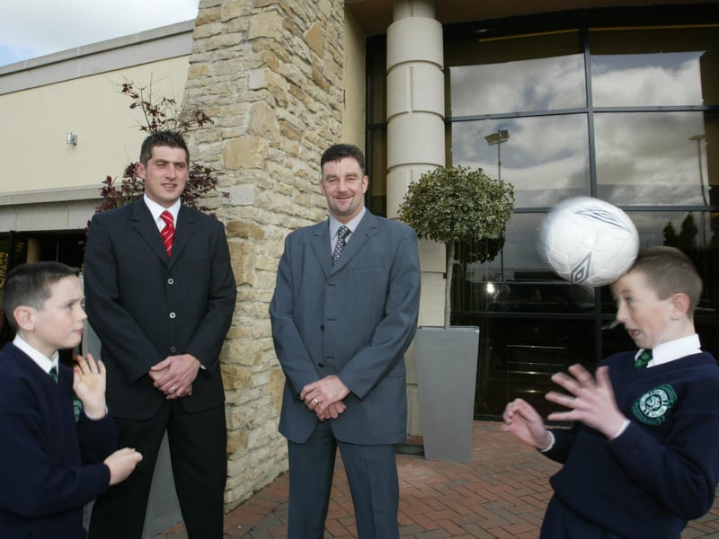 Local primary schoolboys Andrew King and Conor Gallagher demonstrate their heading skills as Declan Devine and John Aldridge look on when they attended the launch of the Derry City soccer academy.  (1605JB09) 