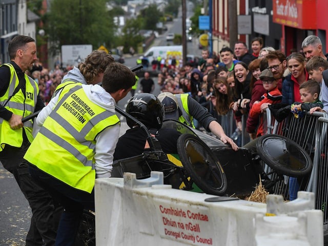 A competitor gets a helping hand after colliding with a bale of hay during the Soap Box Derby run, held in Carndonagh, on Saturday afternoon. Photo: George Sweeney