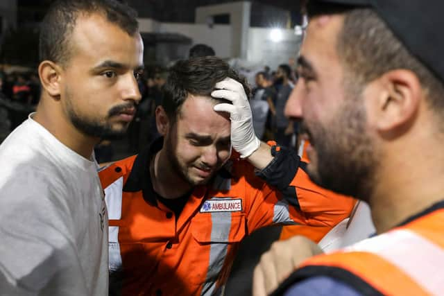 Palestinian paramedics cry outside Al-Shifa hopsital in Gaza City on October 16, 2023, as more than one million people have fled their homes in the Gaza Strip in scenes of chaos and despair amid continuing bombardment by Israeli forces of the Hamas-run Plaestinian territory. Israel declared war on Hamas a day after waves of its fighters broke through the heavily fortified border on October 7, killing more than 1,400 people. (Photo by Dawood NEMER / AFP) (Photo by DAWOOD NEMER/AFP via Getty Images)