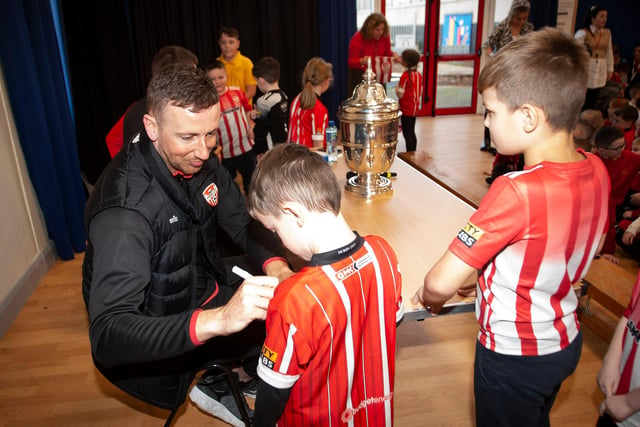 Derry City's Shane McEleney signs autographs for young supporters during his visit to Steelstown Primary School this week with the FAI Cup. (Photo: Jim McCafferty)