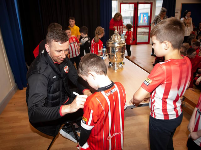 Derry City's Shane McEleney signs autographs for young supporters during his visit to Steelstown Primary School this week with the FAI Cup. (Photo: Jim McCafferty)