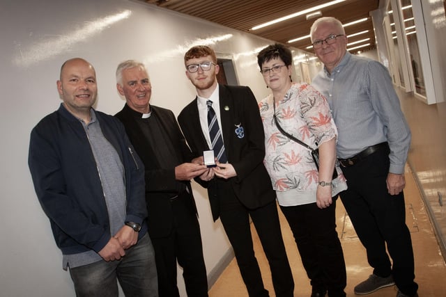 Fr. Michael Canny, board of governors, St. Columb's College presenting Damian McGuinness with the Best GCSE Result in Business Studies and Mathematics Award (co-winner) award at last week's prizegiving. Included on left is Rory Boyd's dad (co-winner), and on right, Damian's parents.