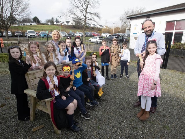 WELL DONE ACCELERATED READERS!. . . . . Mr. Feargal Friel, Principal, Hollybush PS pictured handing over a book marker to Katie Lynch who recently achieved her 2,000,000 word count target on Thursday during World Book Day celebrations. Included are other children who achieved similar awards, and at back, Mrs. Houston, teacher. (Photos: JIm McCafferty Photography)