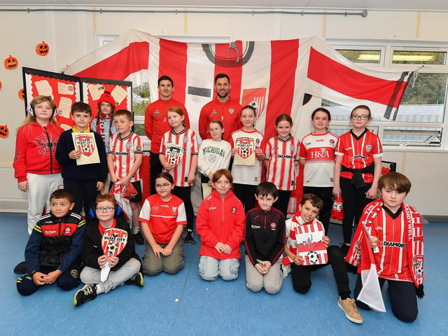 Pupils from Gaelscoil Eadain Mhoir pictured with Derry City’s Ciaran Coll and Pat Hoban during their visit to the school on Monday morning. Photo: George Sweeney