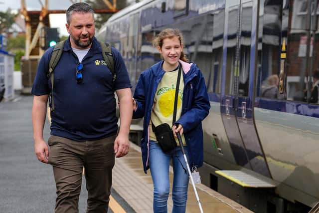Pictured L-R: Anthony O'Neill, Guide Dogs NI, with Elodie, walking along Castlerock platform.:Visually impaired young people enjoy public transport experience