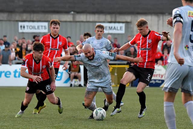 Derry City‘s Adam O’Reilly and Ronan Boyce tackle Shelburne’s Mark Coyle. DER2321GS - 
