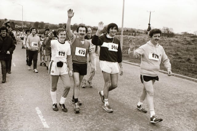 All smiles for the Journal photographer as these runners make their way to the start line.