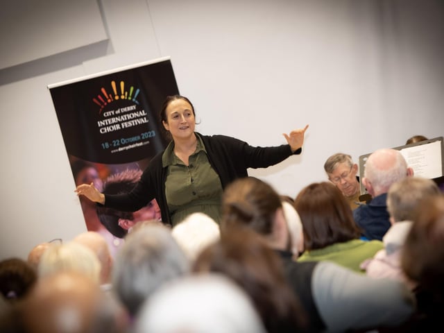 Anna Nolan, Mellow Deeds Choir Director teaches the audience “ I Want To Sing, Sing, Sing!” on Thursday.