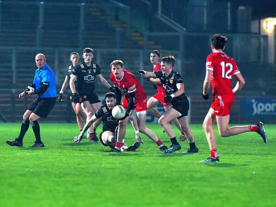 Derry’s Brendan Rogers off loads the ball to Paul Cassidy (12). Photo: George Sweeney
