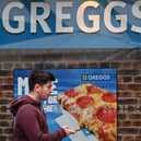 A pedestrian passes a sign for a Greggs bakery in central London on March 5, 2024. (Photo by JUSTIN TALLIS/AFP via Getty Images)