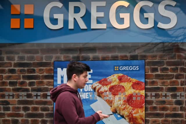 A pedestrian passes a sign for a Greggs bakery in central London on March 5, 2024. (Photo by JUSTIN TALLIS/AFP via Getty Images)