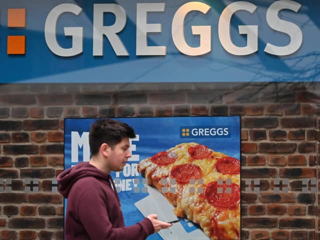A pedestrian passes a sign for a Greggs bakery in central London on March 5, 2024. (Photo by JUSTIN TALLIS/AFP via Getty Images)