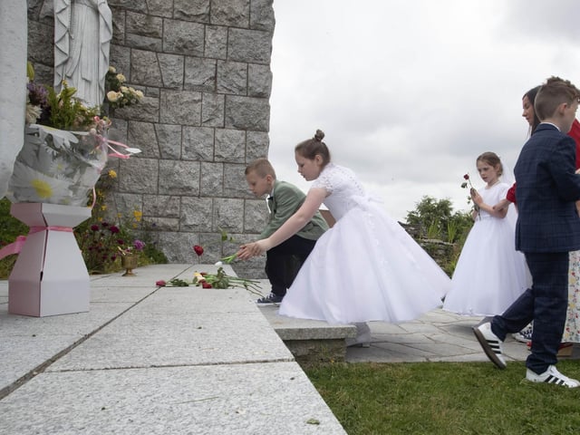 Pupils lay flowers at the St. Mary's Church Grotto on Thursday morning.