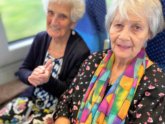 Margaret Robertson and Nellie Brolly clapping along to the U3A Ukulele Band on the return journey from Coleraine to Derry