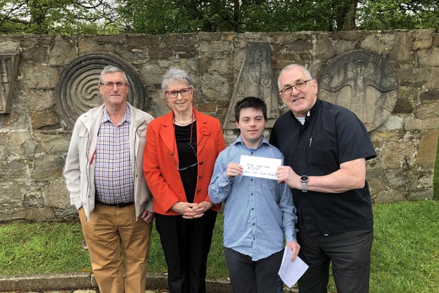 Father Patrick Baker pictured receiving a cheque for €3,167 from Colm Doherty, proceeds from the Burt Book Sale, going towards Parish Funds, Also pictured is John Gillespie , member of the book team and Kathleen Grant (organiser )