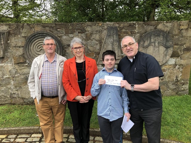Father Patrick Baker pictured receiving a cheque for €3,167 from Colm Doherty, proceeds from the Burt Book Sale, going towards Parish Funds, Also pictured is John Gillespie , member of the book team and Kathleen Grant (organiser )