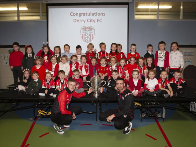 Derry players Caoimhin Porter and Michael Duffy and the FAI Cup pictured with the P2 classes at Greenhaw PS.