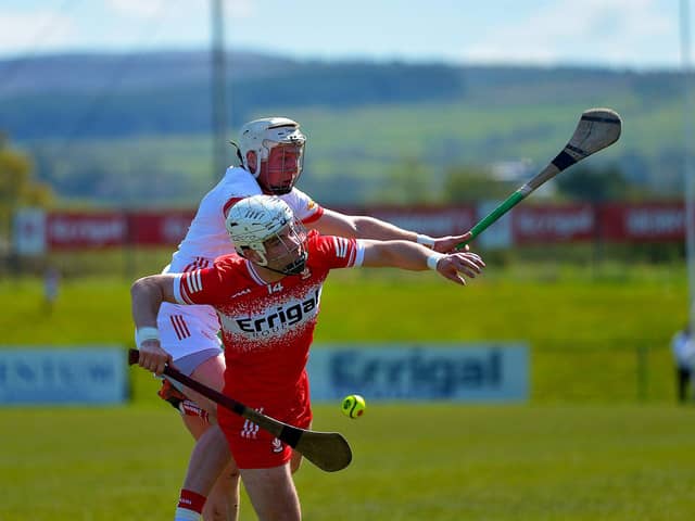 Derry’s Dara Mooney and Tyron’s Dean Rafferty contest a loose sliothar. Photo: George Sweeney