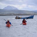 John Hubbocks, Tessa Fleming and Irial Ó Ceallaigh approach Gabhla Island with fishing boat behind them.