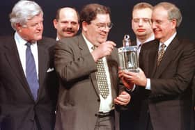 US Senator Ted Kennedy of Massachusetts (L) watches as Nobel Peace Prize winner John Hune (C) looks over the John F. Kennedy Profile in Courage award he was awarded along with former US Senator George Mitchell (R), who chaired the Irish peace talks, David Ervine of the Irish Progressive Unionist Party (L back), and Gary McMichael (R back) of the Irish Ulster Democratic Party during a ceremony at the Kennedy Library in Boston, Massachusetts. AFP PHOTO/John MOTTERN (Photo by JOHN MOTTERN / AFP) (Photo by JOHN MOTTERN/AFP via Getty Images)