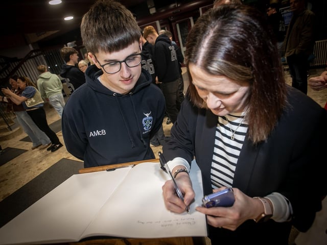 Year 14 student Aidan McBride watches as his mum add a comment to the year book during St. Columb's College Valedictory celebrations. : .