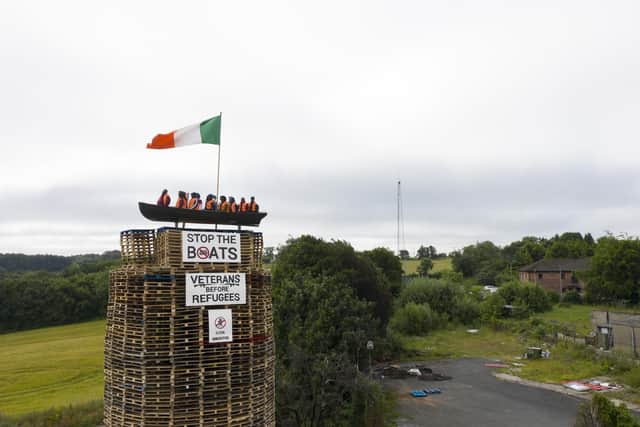 MOYGASHEL, JULY 10: A model of a small boat with several figures depicting migrants inside can be seen on top of a loyalist bonfire on July 10, 2025 in Moygashel. Loyalists have constructed a bonfire effigy depicting a boat full of migrants with mannequins wearing lifejackets and placards reading "Stop the boats," and "Veterans before refugees." The effigy was burned atop a pyre of pallets on Thursday night. Moygashel Bonfire Committee has said that the bonfire "topper" should not be seen as "racist, threatening or offensive" and it is "expressing our disgust at the ongoing crisis that is illegal immigration". (Photo by Charles McQuillan/Getty Images)