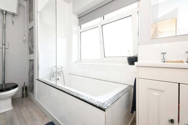 The final room to take a look at is this family bathroom, which comprises a three-piece suite with panelled bath and mixer tap, high-level flush WC, wash hand basin and vanity unit, fitted, waterproof laminate flooring and partly tiled walls. There is also an airing cupboard and a radiator.