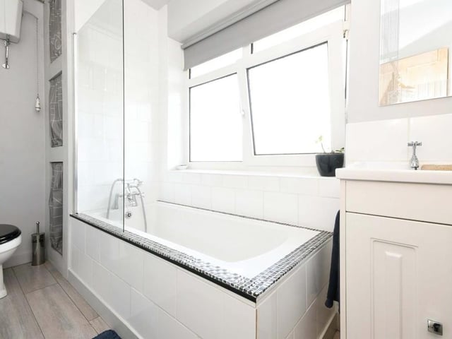 The final room to take a look at is this family bathroom, which comprises a three-piece suite with panelled bath and mixer tap, high-level flush WC, wash hand basin and vanity unit, fitted, waterproof laminate flooring and partly tiled walls. There is also an airing cupboard and a radiator.