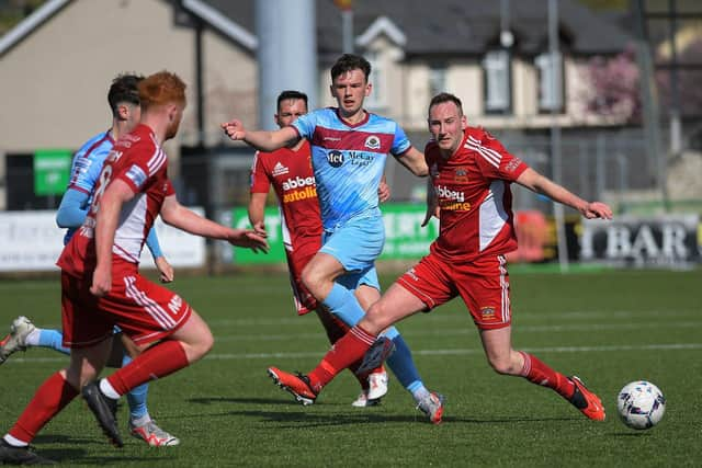 Institute’s Liam Mullan off loads the ball under pressure. Photograph: George Sweeney