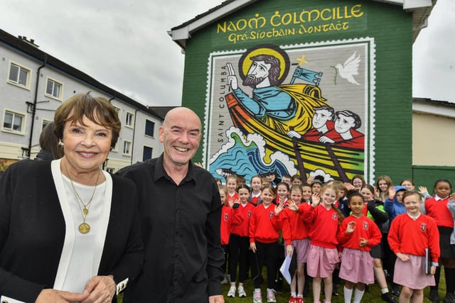 Dana Rosemary Scallon and Abbey B&B proprietor Séamus O'Cinnéide pictured with pupils from St Eugenes Primary School at the mural of St Columba, in Columbcille Court, celebrating the patron saint of Derrys feast day. Photo: George Sweeney