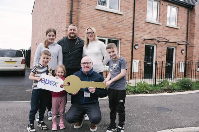 Krystyna Carlin with her husband Colin and four children as they received the keys to their new home in Tygore Park, Eglinton, from David Coll of Apex.