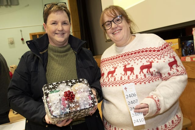 Roisin McLaughlin, one of the winners at the St. Joseph's Boys School Annual Christmas Rickety Wheel on Thursday night, gets her prize from Lisa Grant.