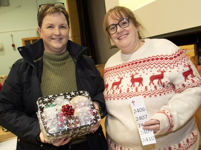 Roisin McLaughlin, one of the winners at the St. Joseph's Boys School Annual Christmas Rickety Wheel on Thursday night, gets her prize from Lisa Grant.