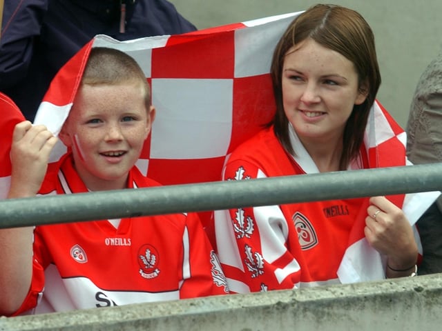 These young fans take shelter from the rain . (3108A21)